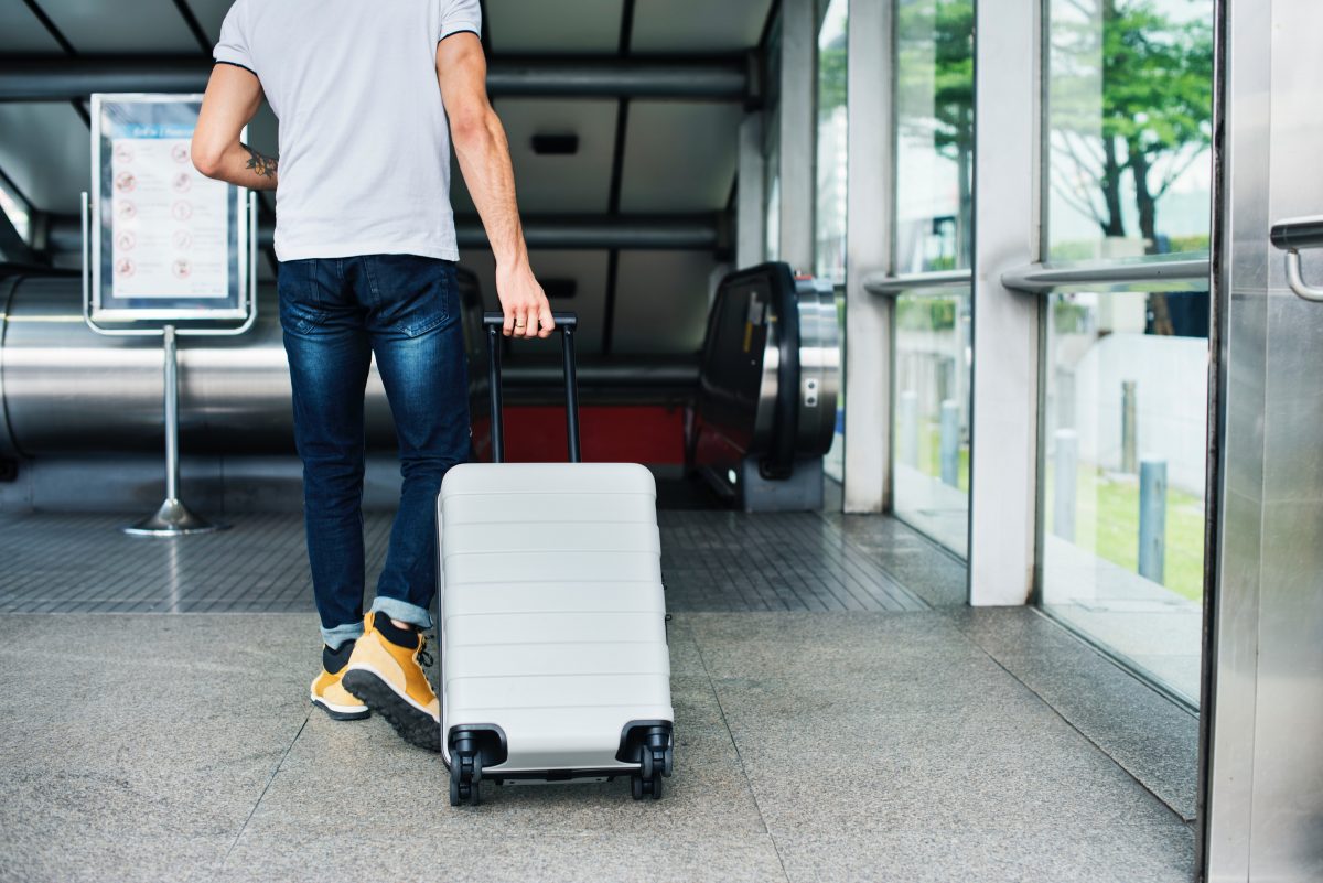 Jeune voyageur avec une valise dans un aeroport ou une gare